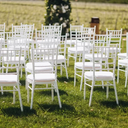 white-chairs-grass-front-wedding-ceremony-arch